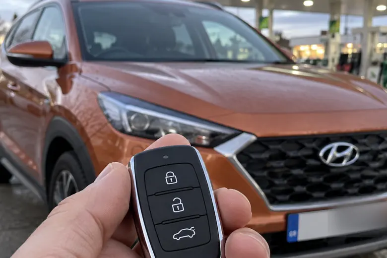 A car key held in front of a Hyundai Tucson
